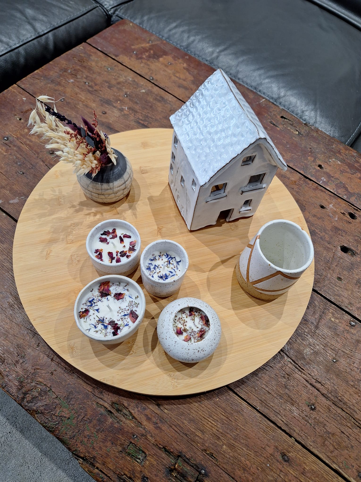 Petite maison en céramique et bols décoratifs sur une table en bois